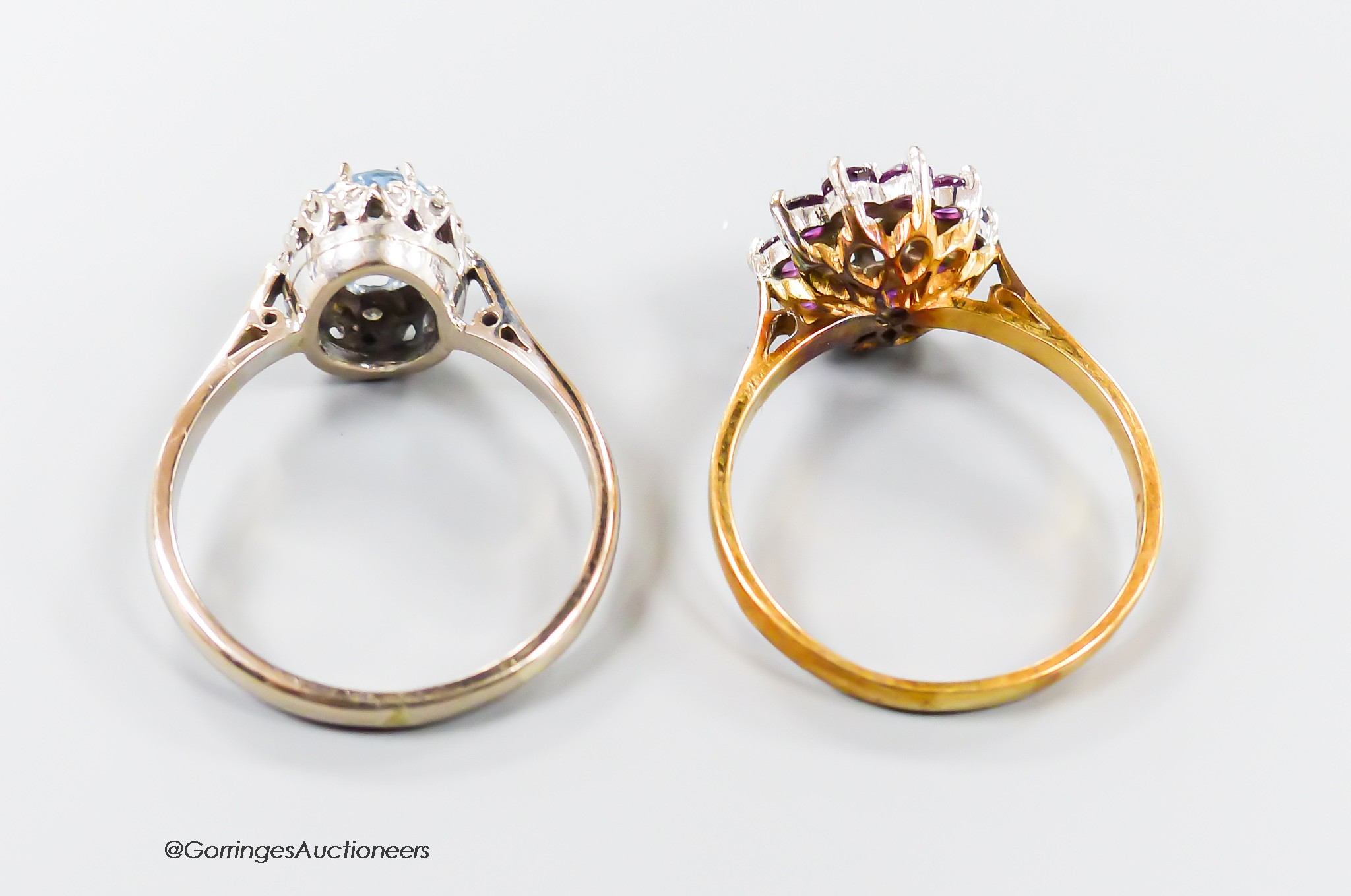 A modern 18th gold, aquamarine and illusion set diamond oval cluster ring, size R and one other 18ct gold, garnet? and diamond set cluster ring, gross 8.8 grams.